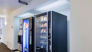 Zona de máquinas expendedoras con una máquina de Pepsi y otra con diferentes snacks.