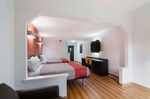 Una habitación de hotel moderna con dos camas, un escritorio y un televisor.