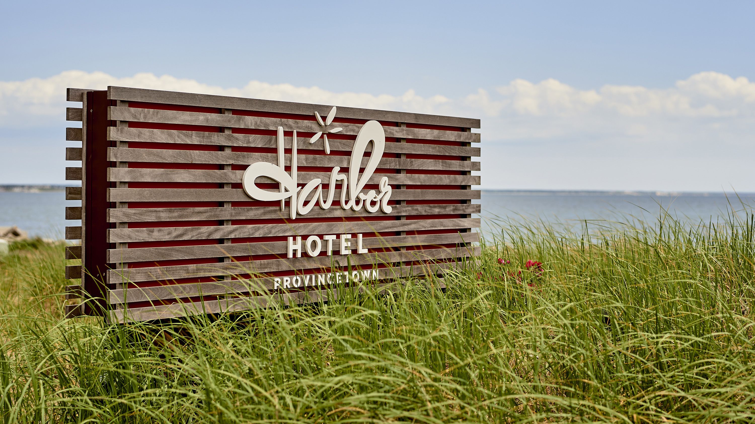 A sign for the Harbor Hotel in Princeton, featuring a wooden slat design with the hotel name and location.