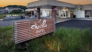 Naamplaatje van Harler Hotel met een overdekt terras en fietsen die er geparkeerd staan.