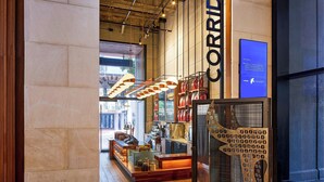 A modern interior with a coffee bar, wooden flooring, and a large 'CORRIDA' sign. - The Worthington Renaissance Fort Worth Hotel (Fort Worth)