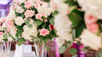A long table with floral centerpieces and candles.
