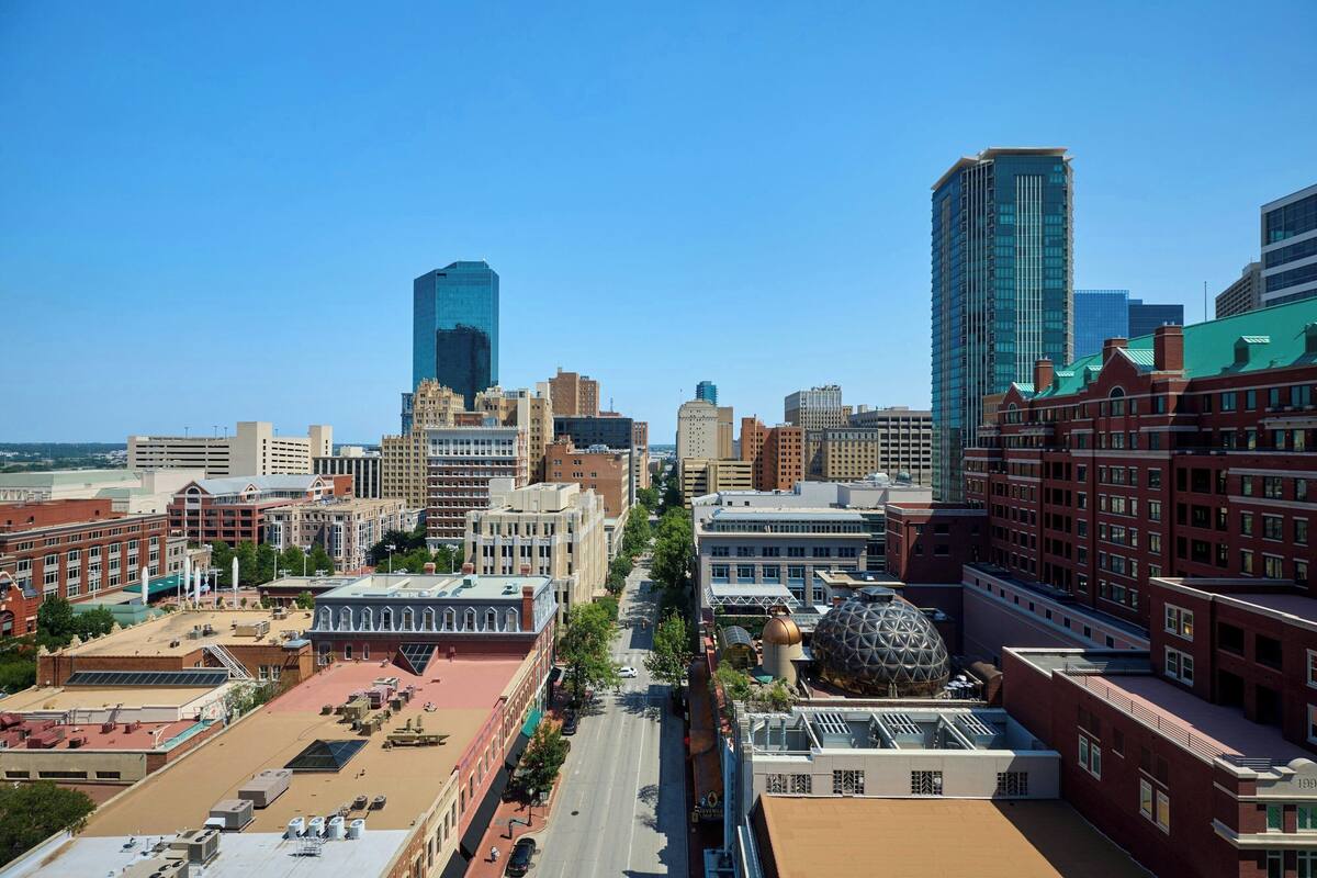 A cityscape with a mix of modern and historic buildings, including a prominent dome structure.