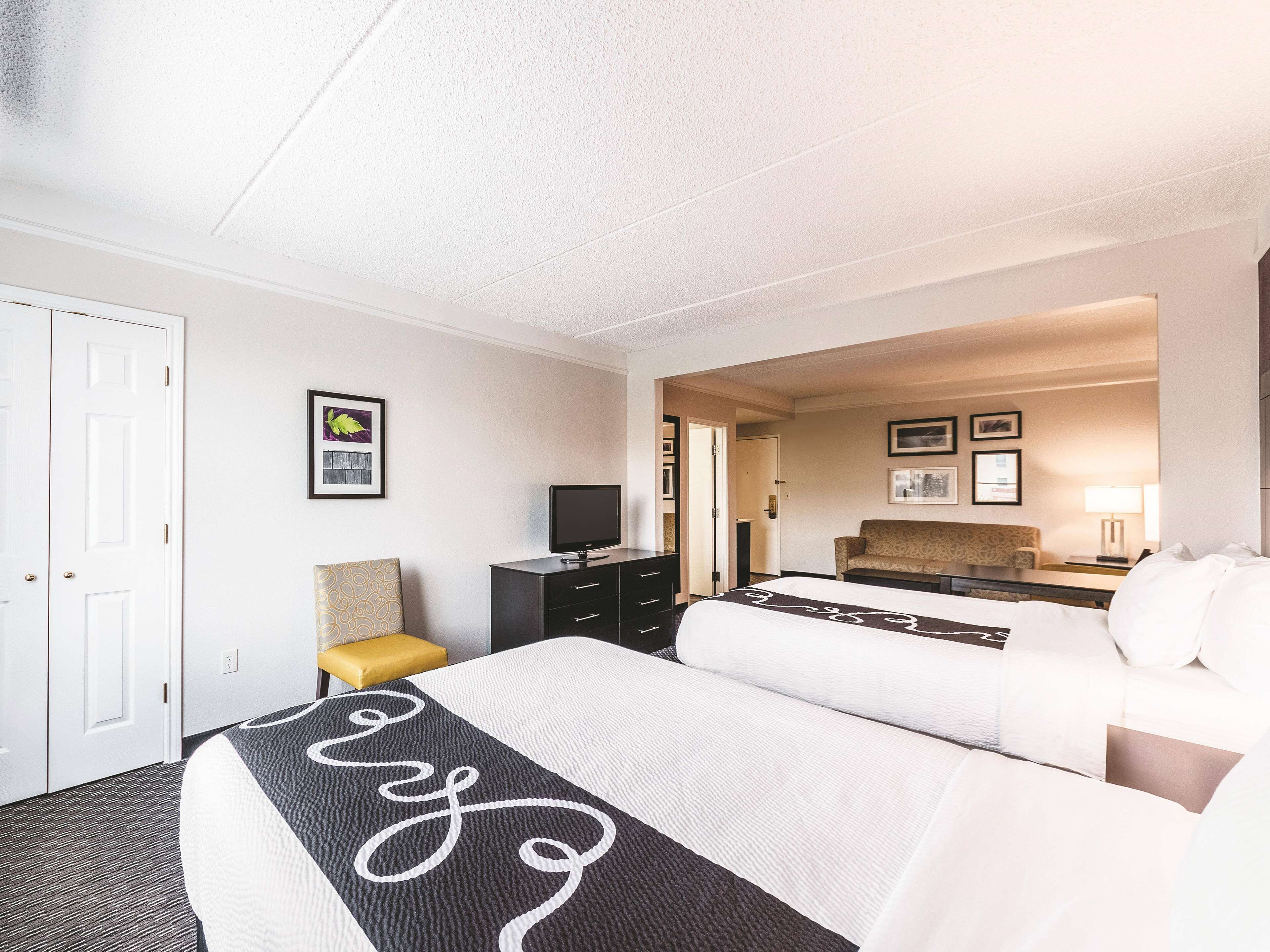 Een hotelkamer met een groot bed, een bureau, een stoel, een televisie en een bank.