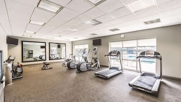 Ein Fitnessstudio mit Laufbändern, Crosstrainern und Gewichten.