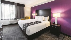 A hotel room with a bed, a chair, a desk, and a lamp. - La Quinta Inn & Suites by Wyndham San Antonio Downtown (San Antonio)