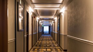 A long, narrow hotel hallway with patterned carpet, doors on both sides, and overhead lighting. - Best Western Plus Hollywood/Aventura (Hallandale Beach)