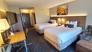 A hotel room with two beds, a desk, a chair, and a TV. - Best Western Plus Hollywood/Aventura (Hallandale Beach)