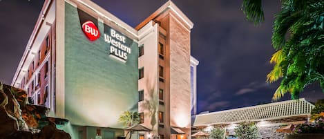 Un hotel con zona de piscina, mobiliario exterior y un cartel que dice 'Best Western Plus'.