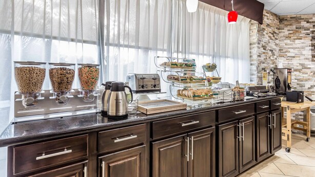 A breakfast bar with a coffee maker, toaster, and various food items.