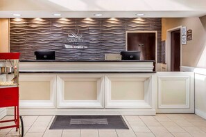 A reception desk with a modern design, a Dell computer, and a red cart. - Quality Inn & Suites Salisbury South (Salisbury)
