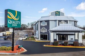 A Quality Inn hotel with a modern design, featuring a covered entrance and a parking lot.
