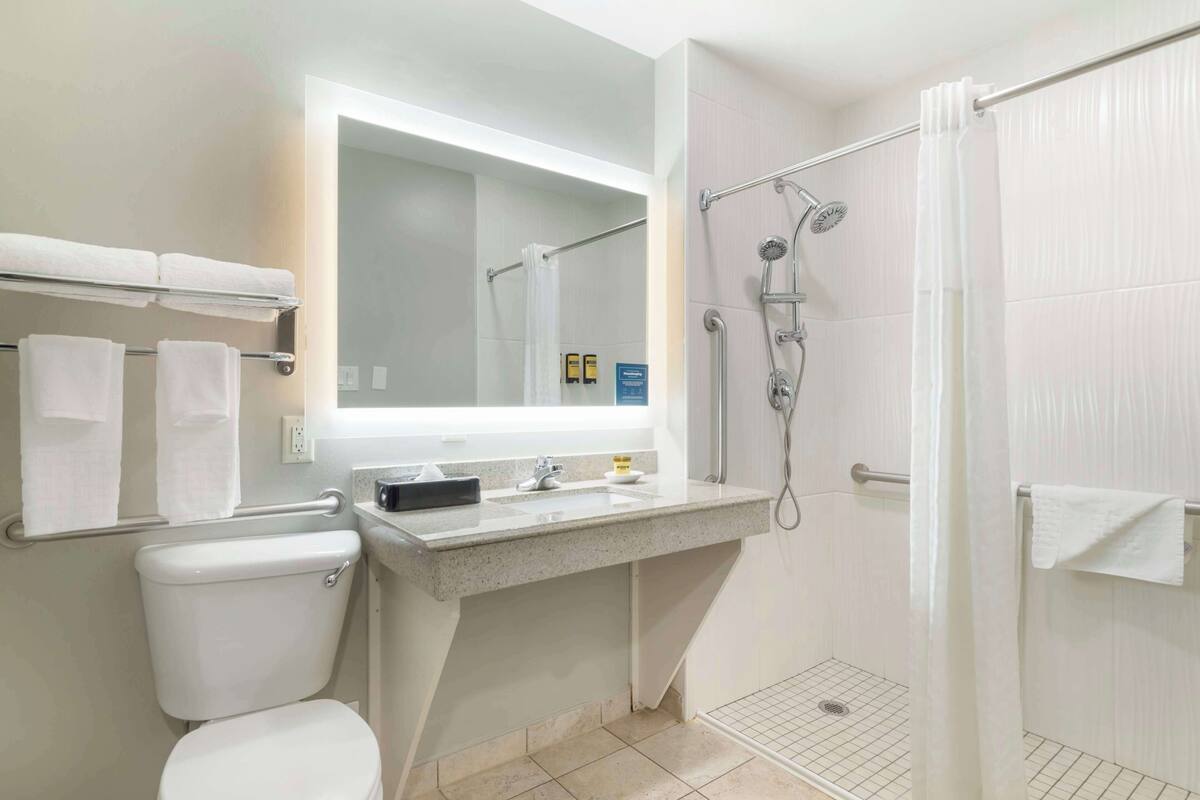 A modern bathroom with a toilet, sink, and shower.