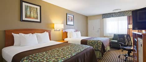 A hotel room with two beds, a desk with a chair, a television, and two framed pictures on the wall.