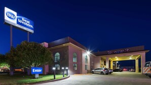 A Best Western Windsor Inn with a clear "Enter" sign, a parking lot, and a building entrance with a ramp. - Best Western Windsor Inn (Dumas)