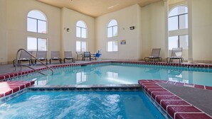 An indoor swimming pool with clear water, surrounded by lounge chairs and a tiled deck. - Best Western Windsor Inn (Dumas)
