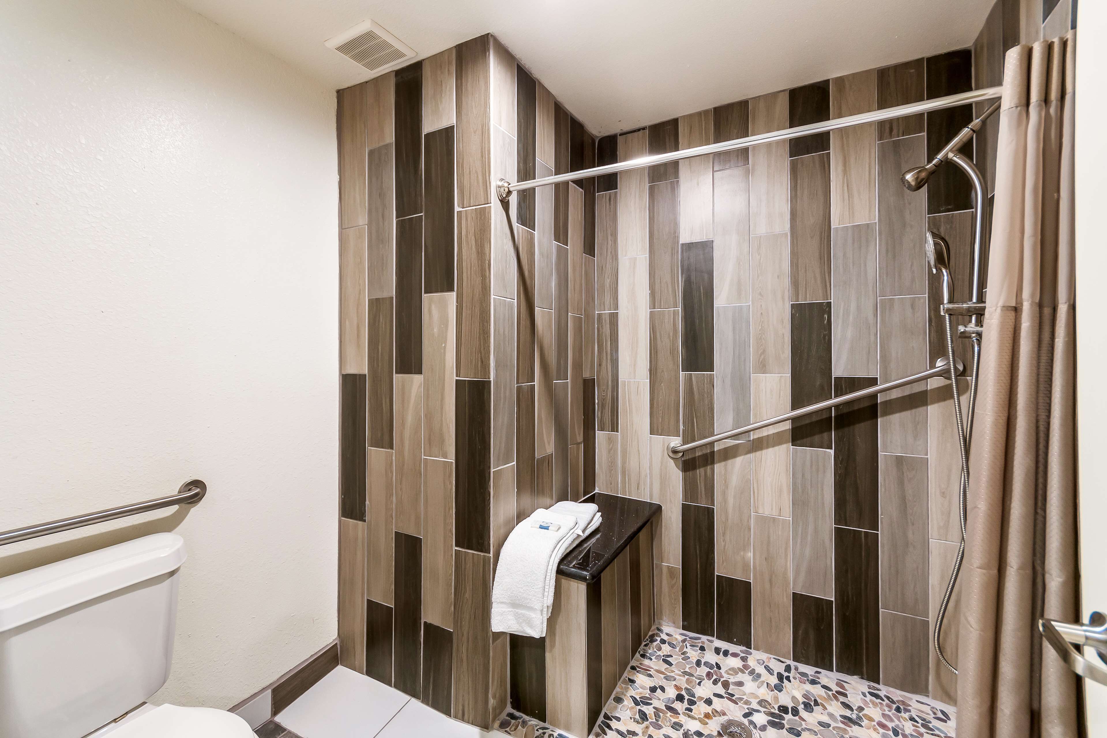 A shower with a glass door, a towel rack, and a showerhead.