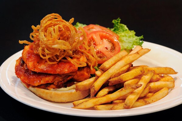 A plate with a burger, fries, and a slice of tomato on a white plate.