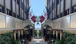 A symmetrical building facade with mirrored architectural elements and flags. - Duroy Hotel (Beirut)