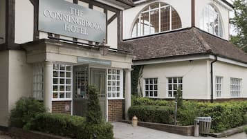 The Conningbrook Hotel with a traditional facade, large windows, and a gravel driveway.