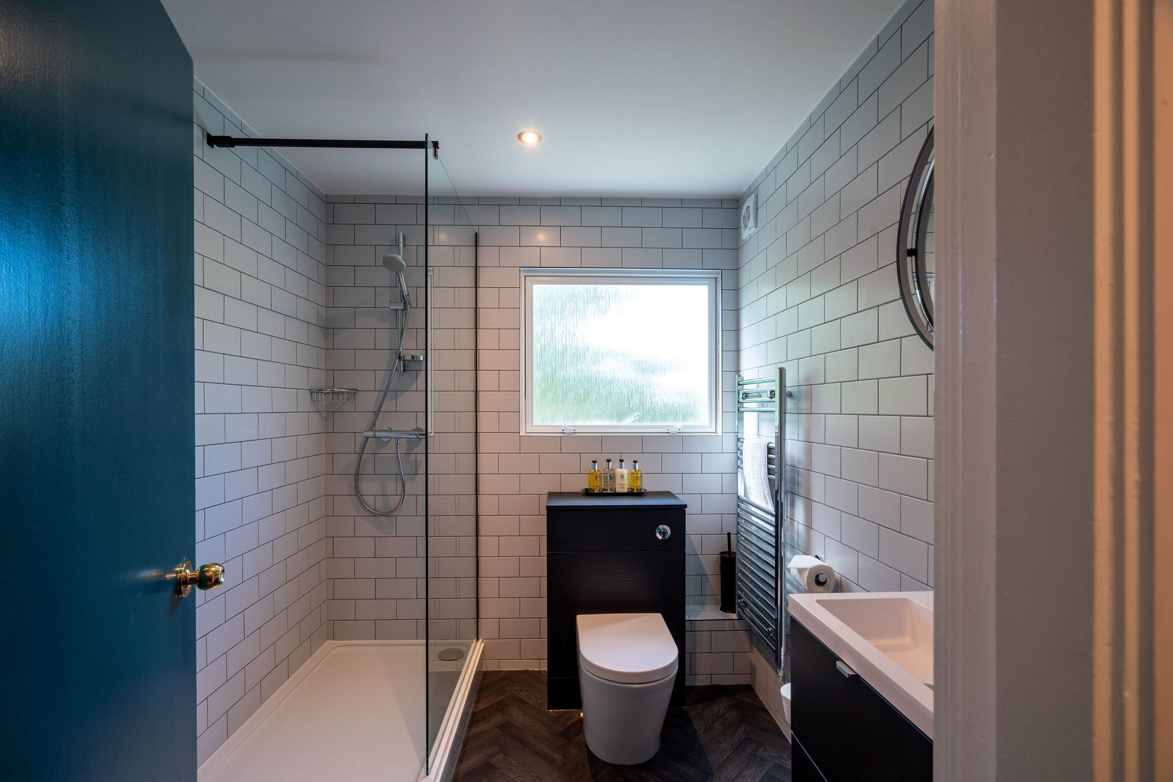 Een moderne badkamer met een inloopdouche, toilet en wastafel.