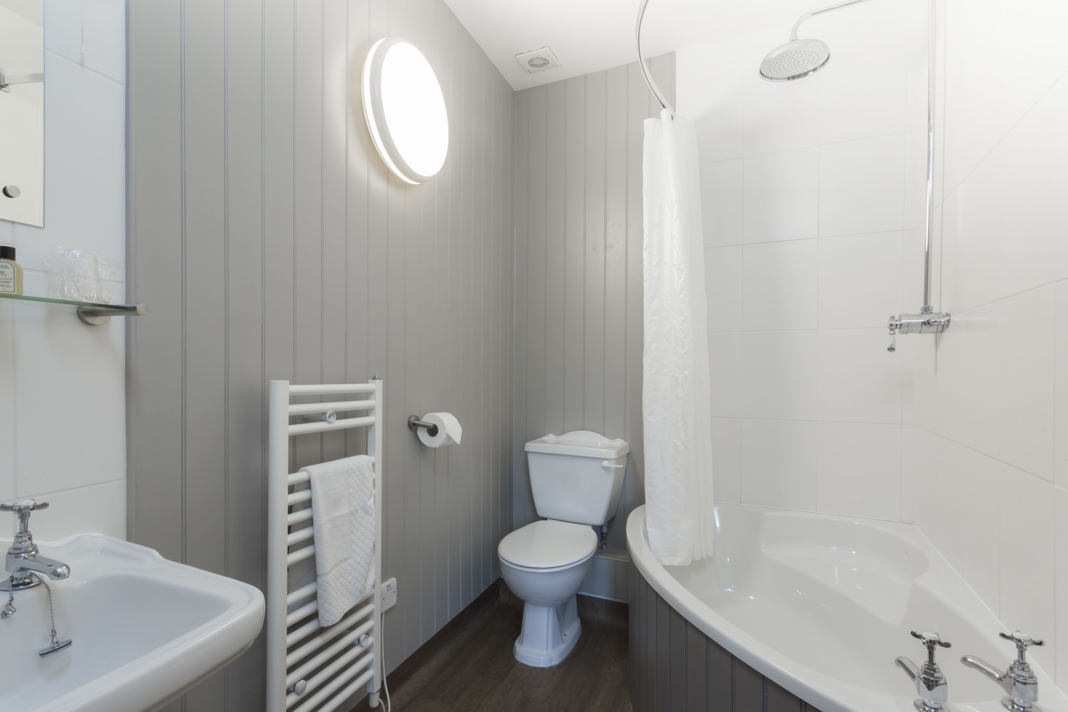 A bathroom with a toilet, sink, and bathtub.