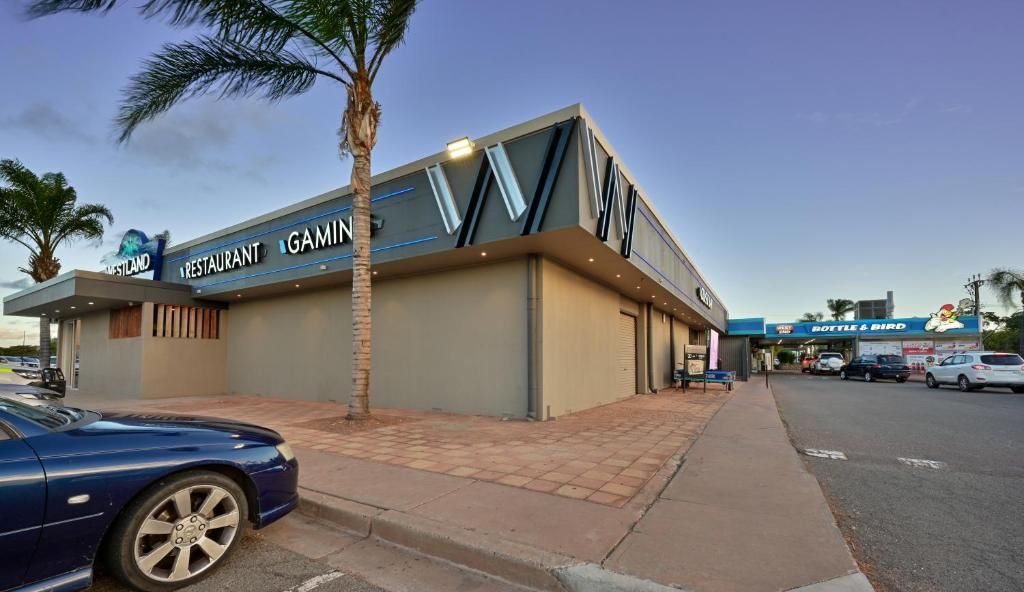 Un bâtiment moderne, avec une enseigne indiquant « GAMIN Restaurant » et « BOTTLE & BIRD » sur la façade.