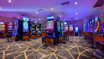 Una fila di slot machine in un casinò, con un tappeto decorato.