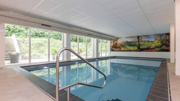 Relax by the pool with a view of the surrounding landscape through large windows.