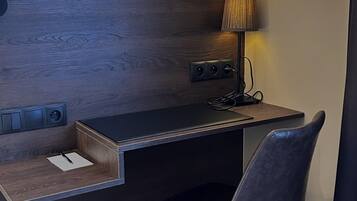 Ein kompakter Arbeitsbereich mit Schreibtisch, Stuhl und Lampe.