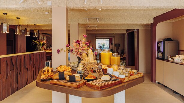 A breakfast buffet with various food items and a fruit display. - Hotel Melba (Bastogne)