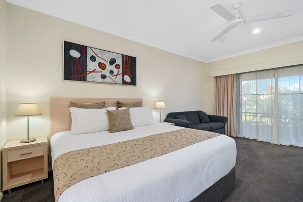Relax in comfort with a large bed, flat-screen TV, and sofa in this inviting space.