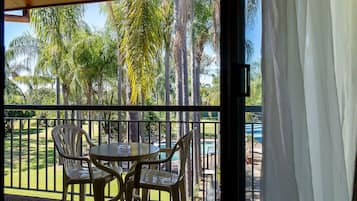 Enjoy a peaceful outdoor space with a lawn view, dining table, and comfortable seating.