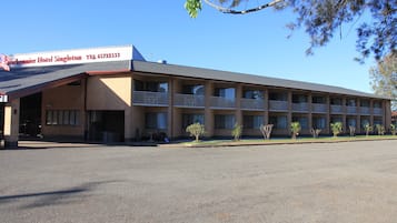 Un hôtel doté d’un toit plat, de nombreux balcons et d’un parking.