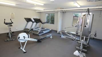 Un gimnasio con cintas de correr, elípticas y máquinas de pesas.