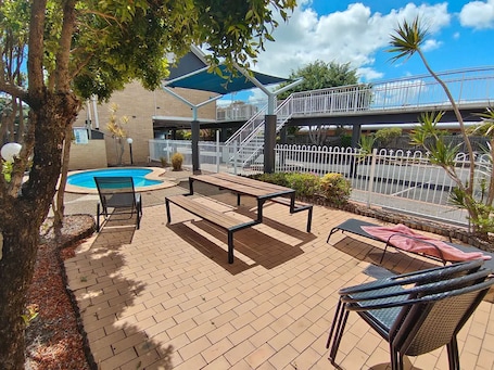 Una piscina al aire libre, sillones reclinables de piscina