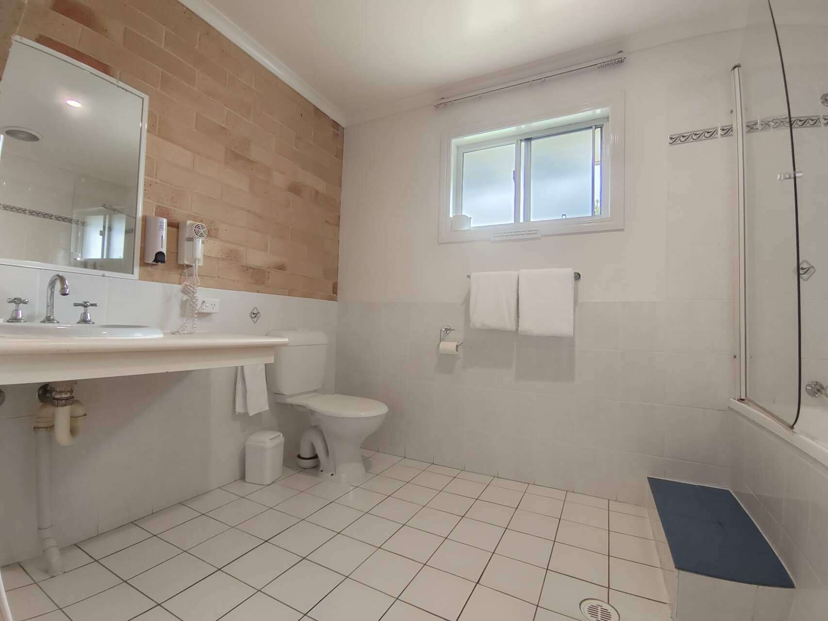 A bathroom with a sink, toilet, and shower.