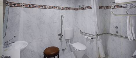 A bathroom with a toilet, sink, and shower.