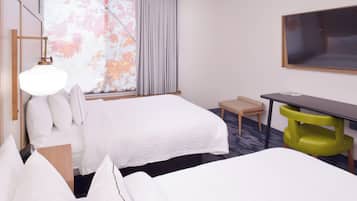 A hotel room with two beds, a desk, a chair, a TV, and a window with curtains.