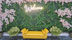 Un espace d’accueil avec une pancarte « Bienvenue », un canapé jaune et deux fauteuils verts.