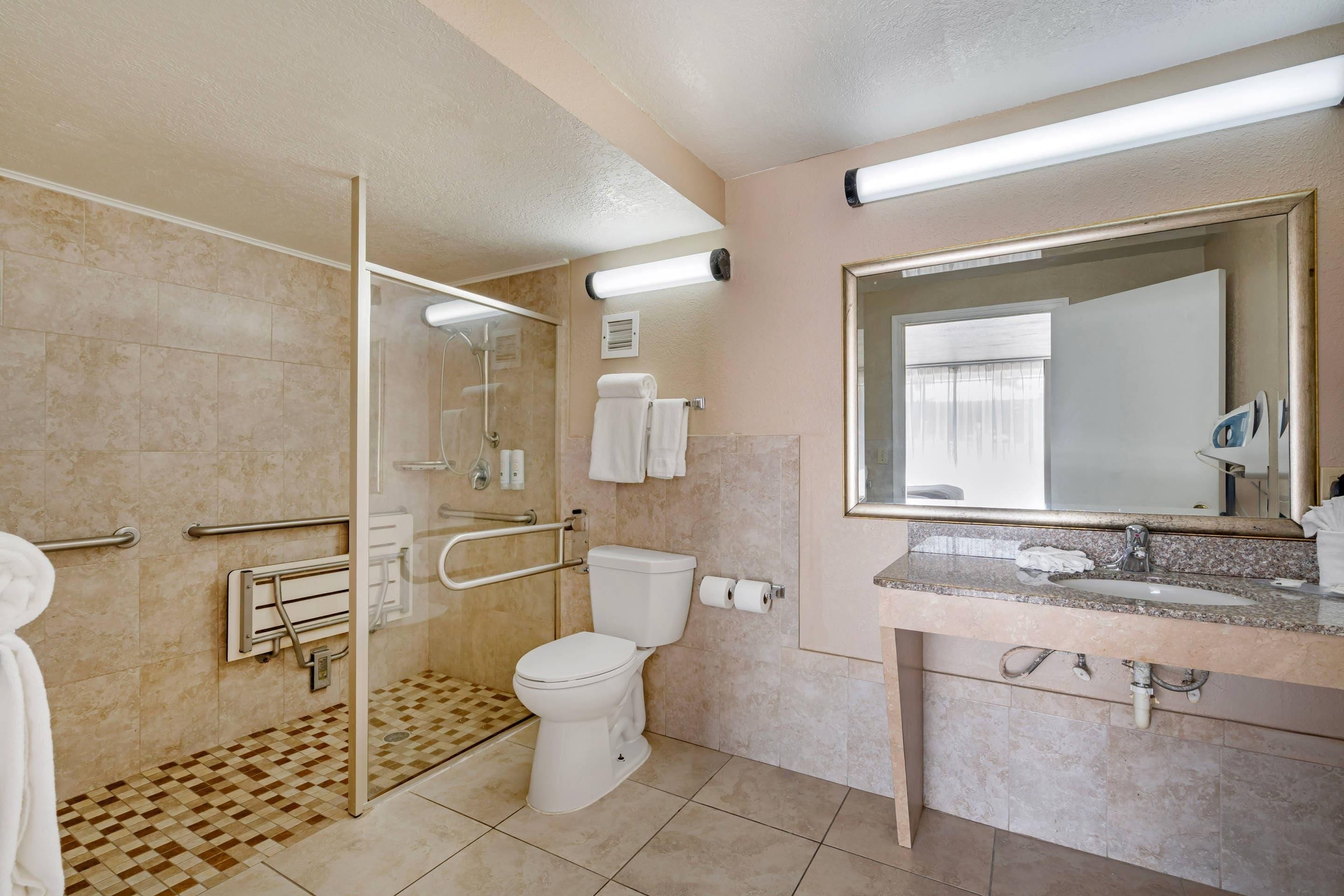 Une salle de bain avec douche, toilettes et lavabo.