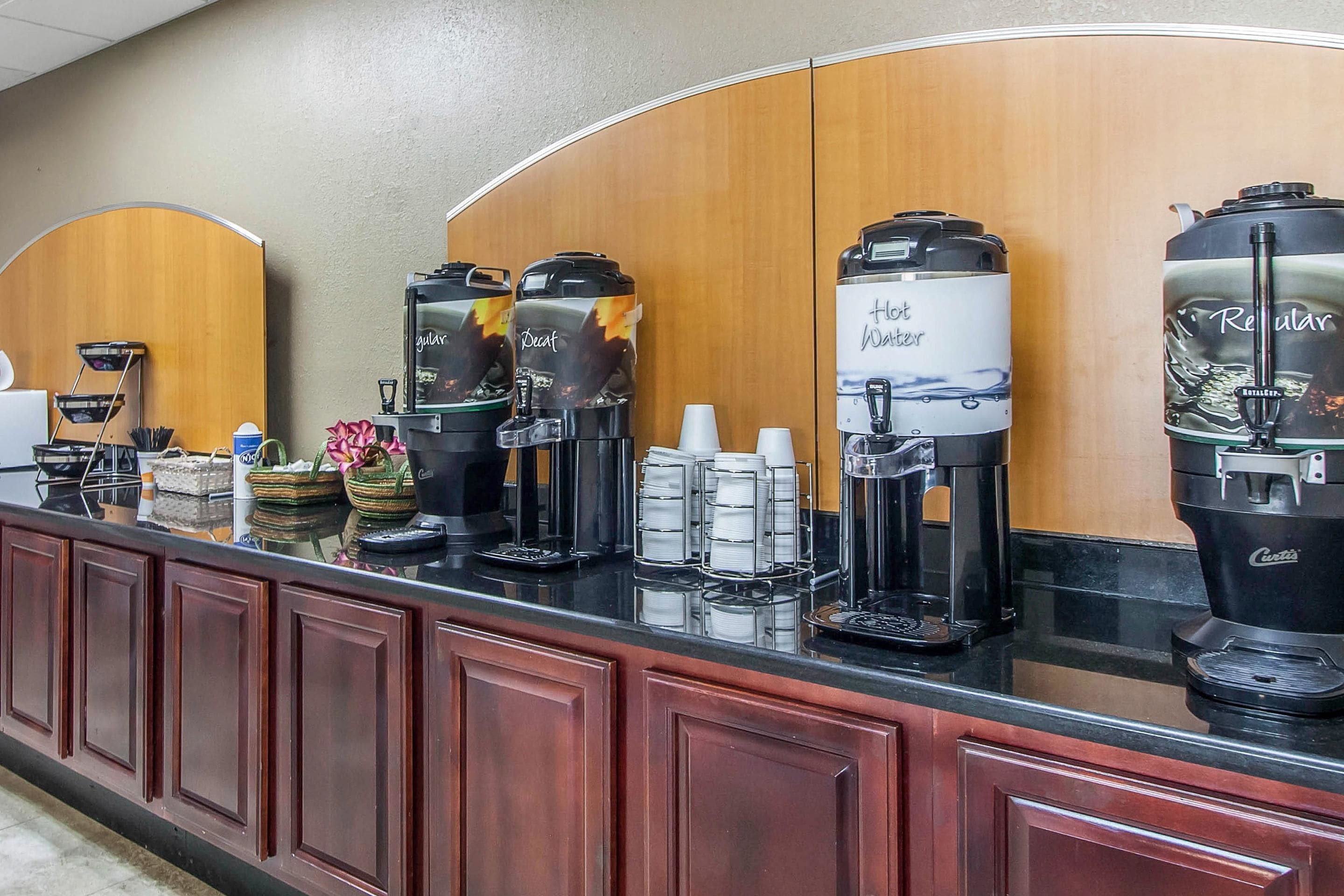 A coffee station with multiple coffee makers, including a 'Hot Water' and 'Regular' option, and a 'GulaVita' branded machine.