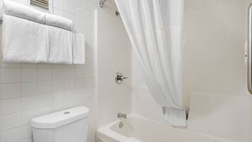 Une salle de bain équipée de toilettes, d’une baignoire et d’un rideau de douche.