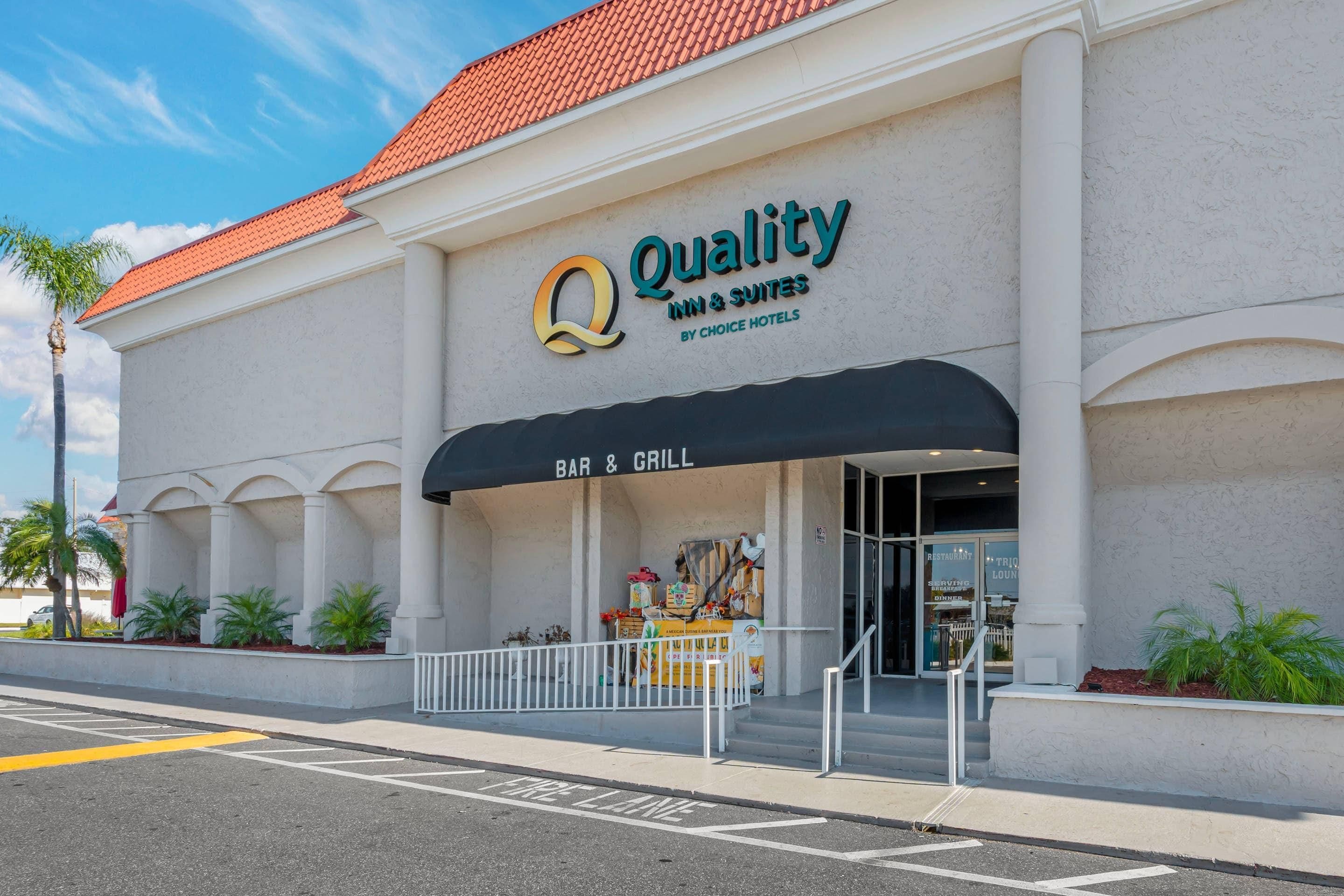 Ein Hotel namens "Quality Inn & Suites by Choice Hotels" mit einem "BAR & GRILL"-Schild.