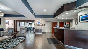 A hotel lobby with a reception desk, seating area, and a view of the cityscape. - Comfort Suites Downtown Sacramento (Sacramento)
