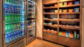 A vending machine stocked with various beverages and snacks, including sodas, chips, and packaged foods.
