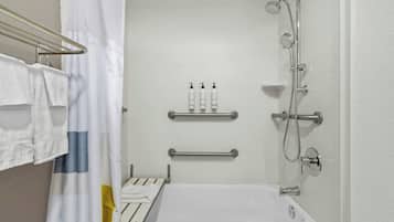 A bathroom with a bathtub, a shower, and a towel rack.