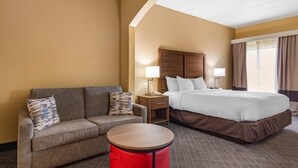 Ein Hotelzimmer mit Bett, Sofa, kleinem Tisch und Nachttisch.