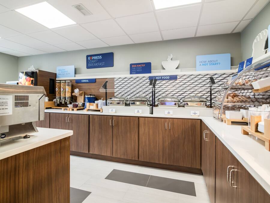 A breakfast area with a self-serve station, cereal, hot food, and a sign promoting a healthy start.