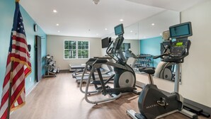 A gym with treadmills, elliptical machines, and a stationary bike.